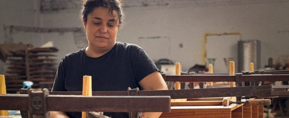Elena encola la estructura de un mueble entre sargentos en el taller de Serrín y Viruta