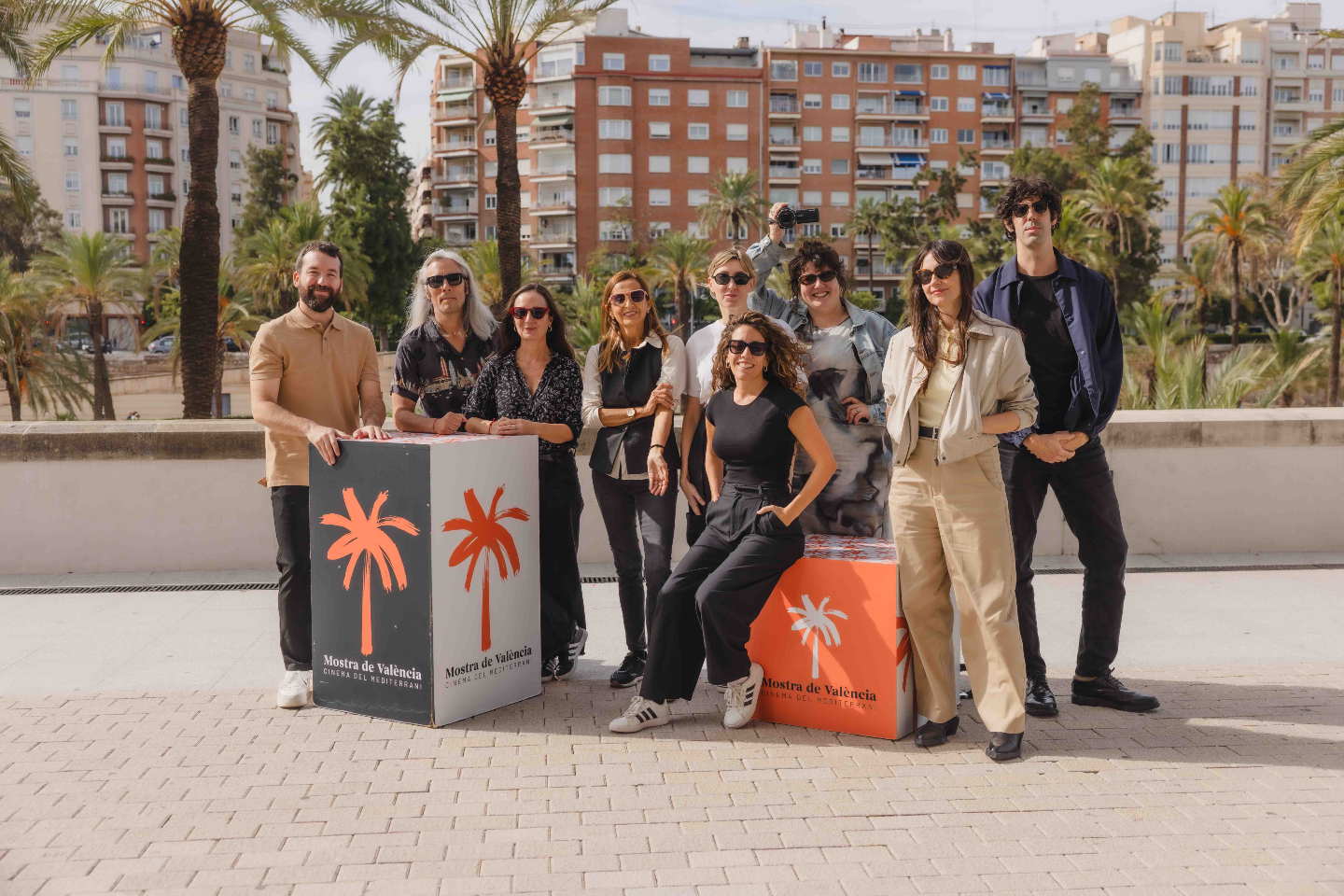 Grupo de creadores valencianos posando junto a cubos con el logotipo de la Mostra de València