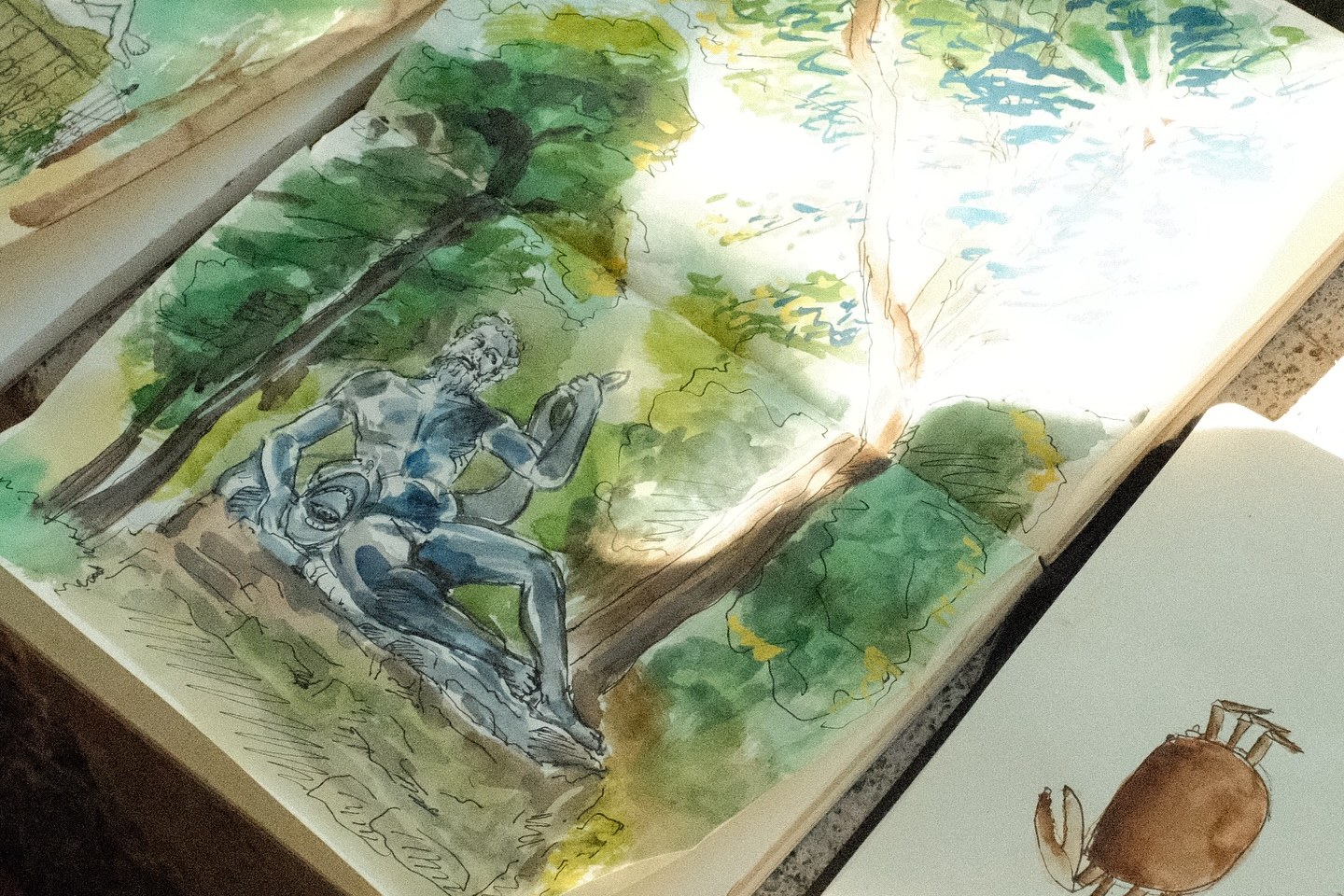 Cuaderno de acuarela y tinta con una estatua entre árboles, dibujado en una quedada de Ojo Garabato