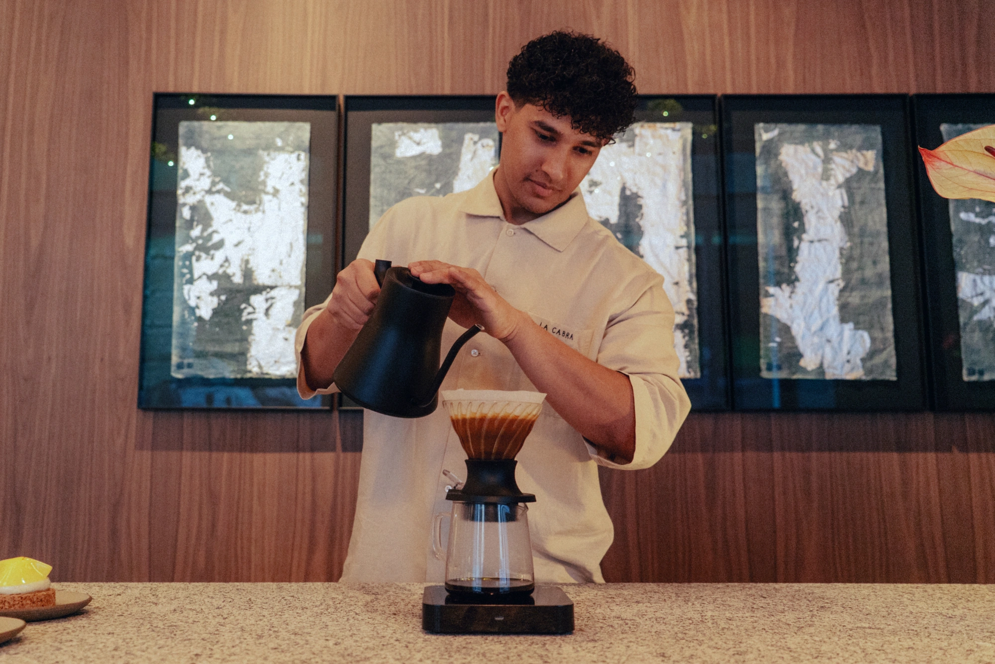 Un barista de La Cabra Madrid prepara un café de filtro en la barra