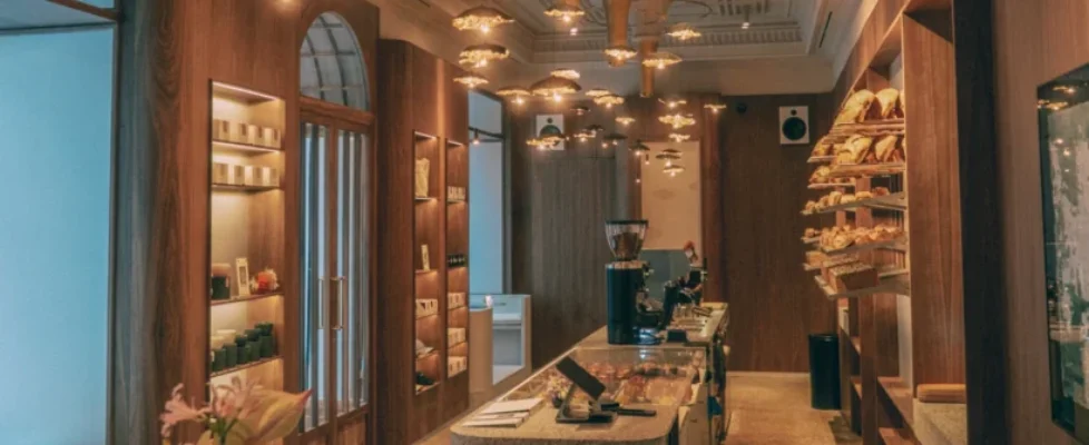 El interior de La Cabra Madrid: mostrador de terrazo, lámparas y panera bajo el techo original