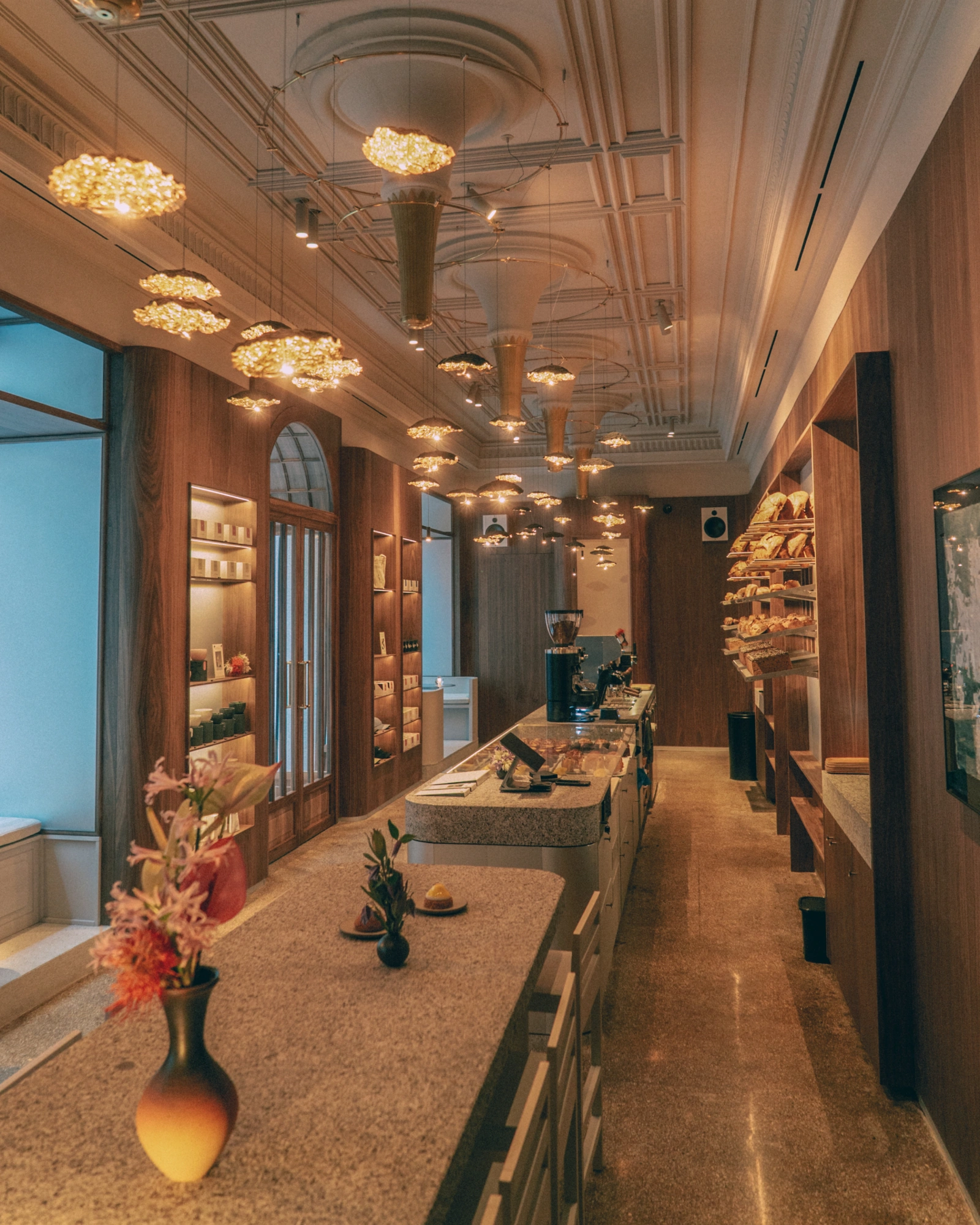 El interior de La Cabra Madrid: mostrador de terrazo, lámparas y panera bajo el techo original