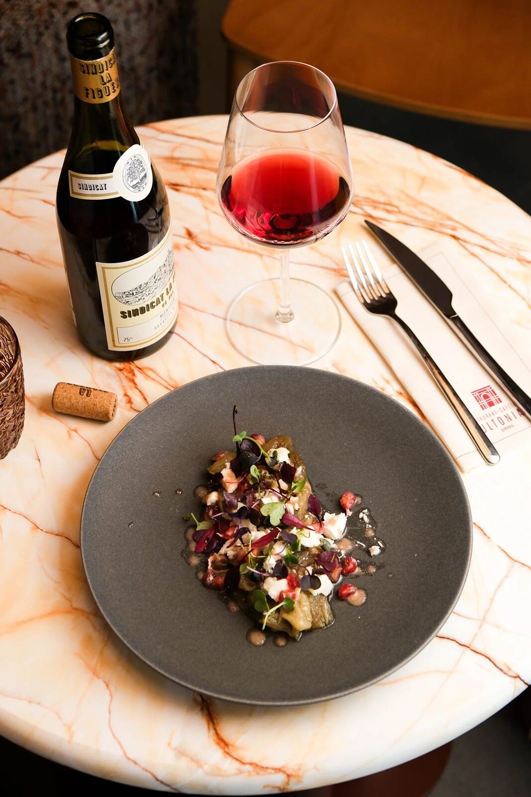 Un plato del Restaurante Ultonia junto a una copa de vino